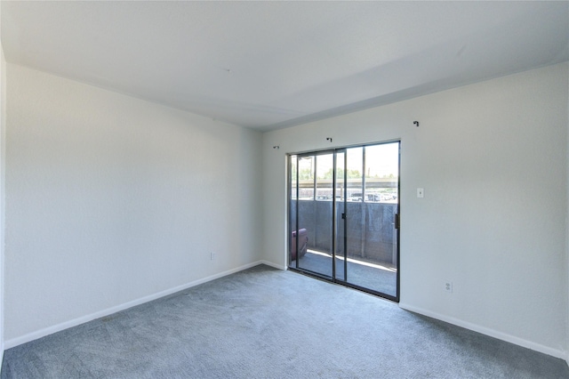 carpeted empty room featuring baseboards
