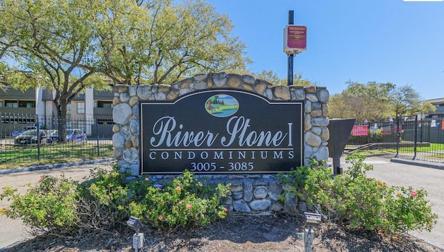 community / neighborhood sign featuring fence