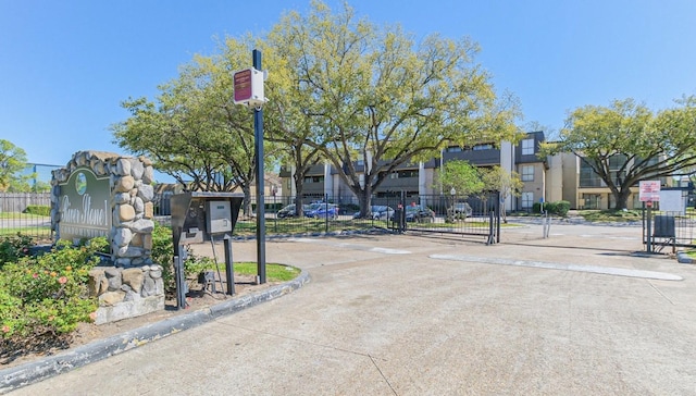 view of concrete street featuring curbs, a residential view, and a gated entry