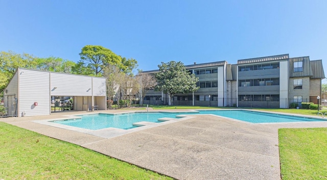 community pool with a patio area and a yard