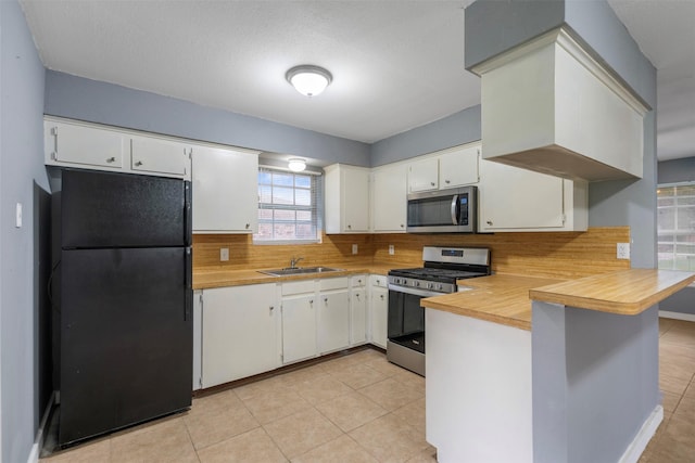 1204 Crescent Blvd, Cleveland, TX 77327 - kitchen with stainless steel appliances, a sink, a peninsula, light countertops, and decorative backsplash