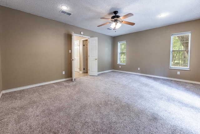 304 Inverness St, Huntsville, TX 77340 - spare room featuring ceiling fan, healthy amount of natural light, light carpet, a textured ceiling, and baseboards