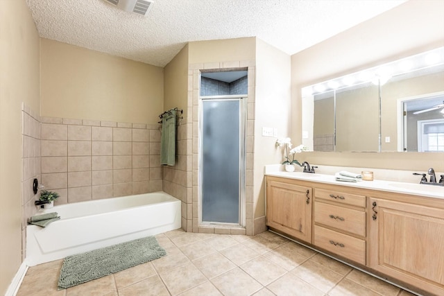 304 Inverness St, Huntsville, TX 77340 - bathroom with tile patterned flooring, a stall shower, double vanity, a garden tub, and a textured ceiling