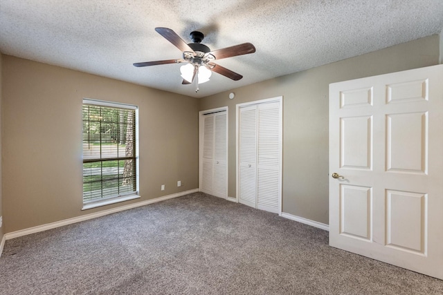 304 Inverness St, Huntsville, TX 77340 - unfurnished bedroom featuring multiple closets, carpet, a textured ceiling, baseboards, and ceiling fan