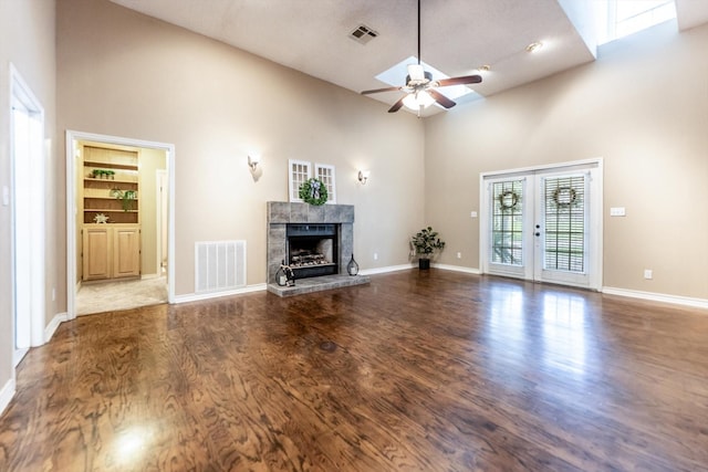 304 Inverness St, Huntsville, TX 77340 - unfurnished living room with a high ceiling, a ceiling fan, a high end fireplace, wood finished floors, and baseboards