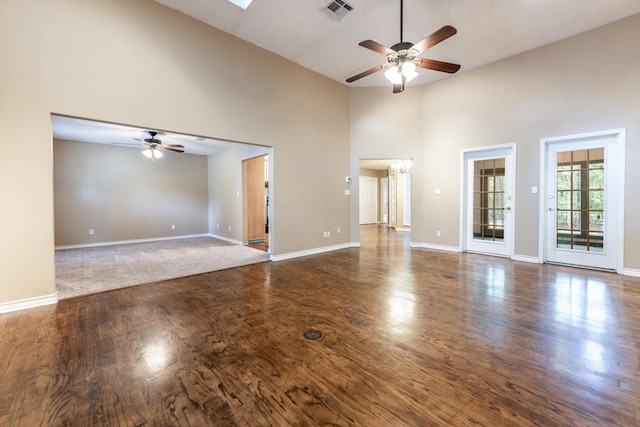 304 Inverness St, Huntsville, TX 77340 - unfurnished living room featuring a ceiling fan, high vaulted ceiling, wood finished floors, and baseboards