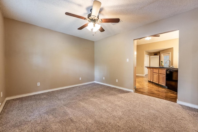 304 Inverness St, Huntsville, TX 77340 - carpeted spare room featuring ceiling fan, baseboards, a sink, and a textured ceiling