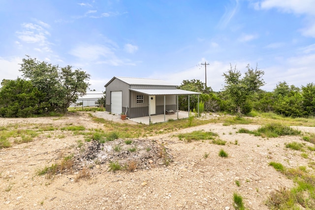 192 Primrose Path, Canyon Lake, TX 78133 - rear view of house with a garage and an outdoor structure