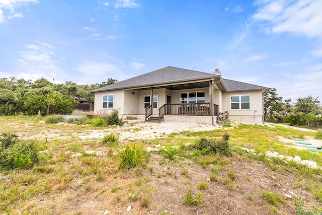 192 Primrose Path, Canyon Lake, TX 78133 - back of property featuring stucco siding, a chimney, and covered porch