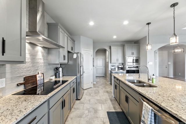 192 Primrose Path, Canyon Lake, TX 78133 - kitchen with arched walkways, a sink, wall chimney range hood, appliances with stainless steel finishes, and recessed lighting