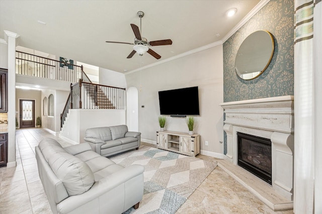 19427 Stanton Lake Dr, Cypress, TX 77433 - living area featuring stairway, ceiling fan, ornamental molding, a glass covered fireplace, and baseboards