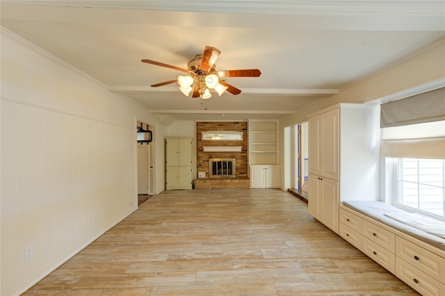 22211 Bucktrout Ln, Katy, TX 77449 - unfurnished living room with ceiling fan, light wood-type flooring, a brick fireplace, built in shelves, and crown molding