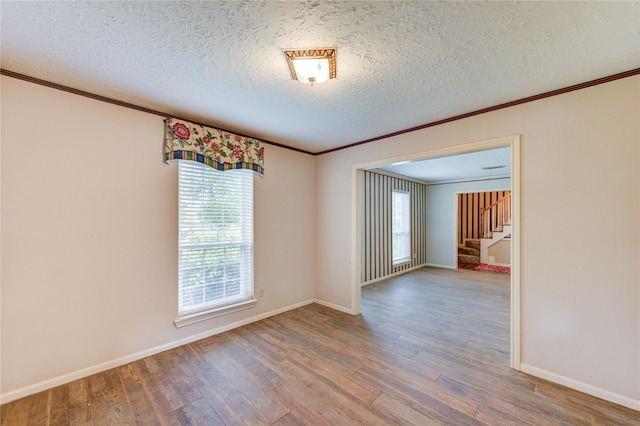 22211 Bucktrout Ln, Katy, TX 77449 - unfurnished room featuring crown molding, wood finished floors, stairs, a textured ceiling, and baseboards
