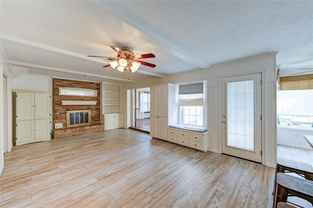 22211 Bucktrout Ln, Katy, TX 77449 - unfurnished living room featuring ceiling fan, healthy amount of natural light, light wood-type flooring, beam ceiling, and a brick fireplace