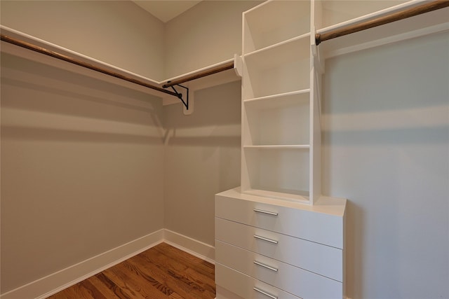 walk in closet with wood finished floors