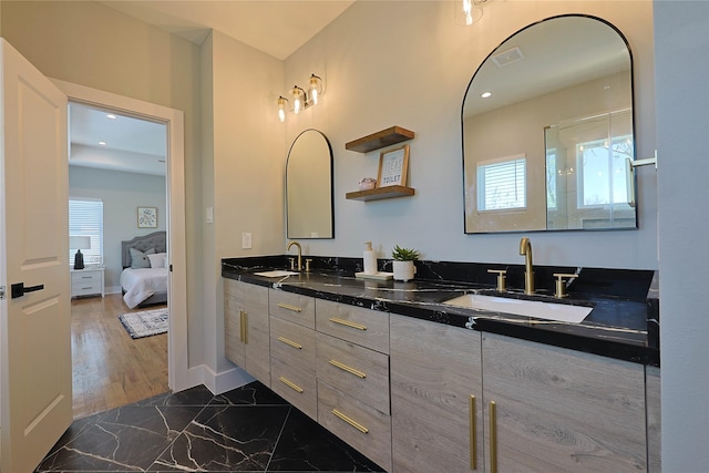 bathroom featuring marble finish flooring, double vanity, ensuite bath, and recessed lighting