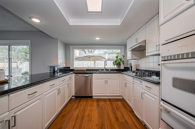 2215 Braesmeadow Ln, Sugar Land, TX 77479 - kitchen with stainless steel appliances, a warming drawer, a sink, white cabinets, and wood finished floors