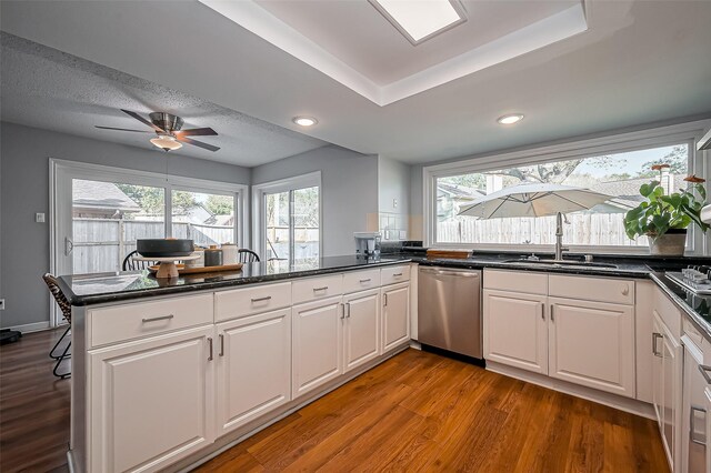 2215 Braesmeadow Ln, Sugar Land, TX 77479 - kitchen with stainless steel dishwasher, a sink, wood finished floors, white cabinetry, and a ceiling fan