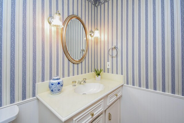 13602 Wendelyn Ln, Houston, TX 77069 - bathroom featuring a wainscoted wall, vanity, and wallpapered walls