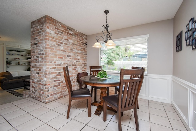13602 Wendelyn Ln, Houston, TX 77069 - dining area featuring light tile patterned floors, a wainscoted wall, a decorative wall, and a textured ceiling