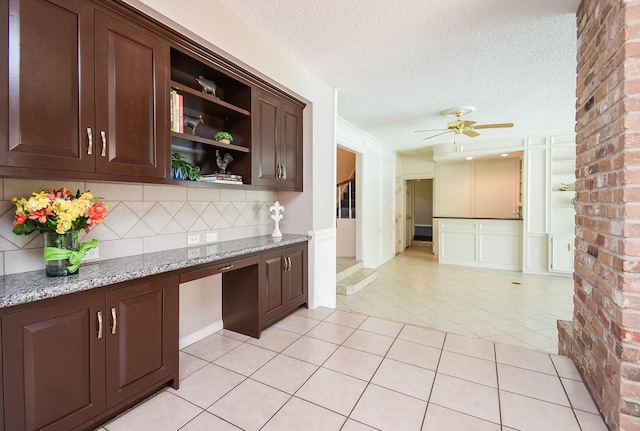 13602 Wendelyn Ln, Houston, TX 77069 - kitchen with open shelves, a ceiling fan, dark brown cabinets, light tile patterned floors, and a textured ceiling