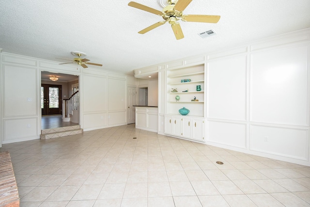 13602 Wendelyn Ln, Houston, TX 77069 - unfurnished living room featuring a decorative wall, ceiling fan, light tile patterned floors, stairway, and a textured ceiling