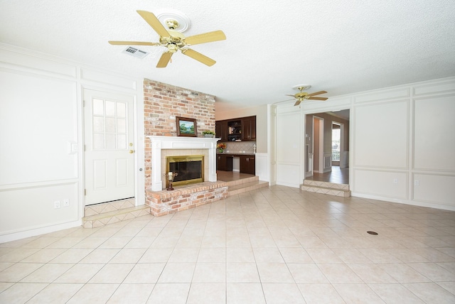 13602 Wendelyn Ln, Houston, TX 77069 - unfurnished living room featuring a decorative wall, ceiling fan, a textured ceiling, a fireplace, and light tile patterned flooring