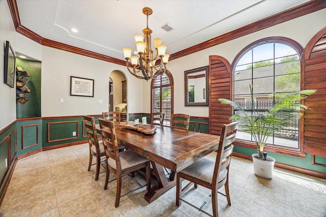 1015 W 41st St, Houston, TX 77018 - dining space with a chandelier, healthy amount of natural light, arched walkways, ornamental molding, and a wainscoted wall