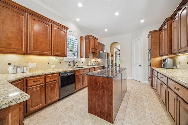 1015 W 41st St, Houston, TX 77018 - kitchen with black appliances, a sink, arched walkways, a center island, and light stone countertops