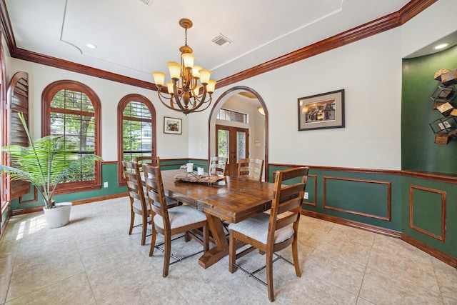 1015 W 41st St, Houston, TX 77018 - dining area featuring a chandelier, ornamental molding, french doors, wainscoting, and arched walkways