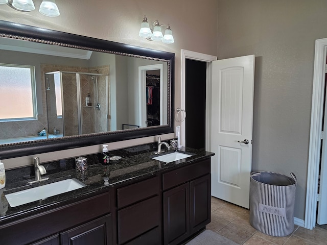 full bathroom with a stall shower, tile patterned floors, double vanity, and a spacious closet