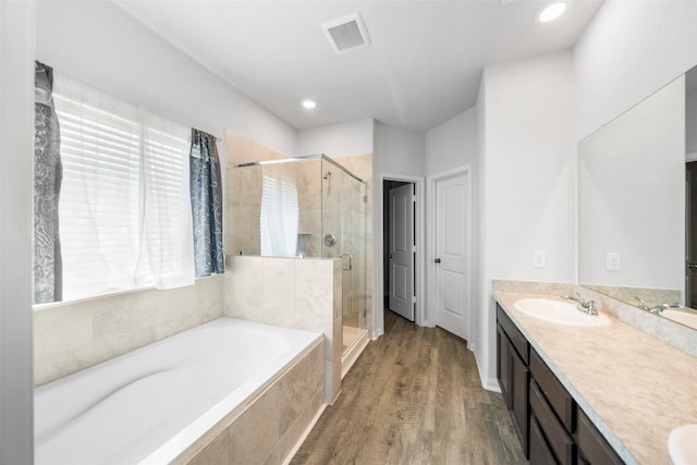 6186 White Oak Leaf Loop, Conroe, TX 77303 - bathroom featuring a bath, a stall shower, double vanity, wood finished floors, and recessed lighting