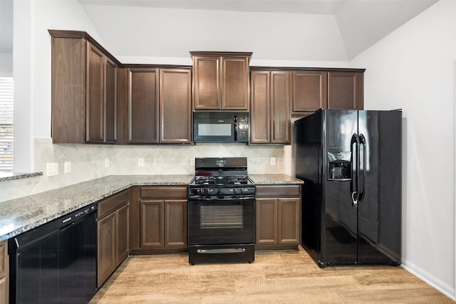 6186 White Oak Leaf Loop, Conroe, TX 77303 - kitchen with black appliances, light stone counters, light wood-type flooring, tasteful backsplash, and lofted ceiling