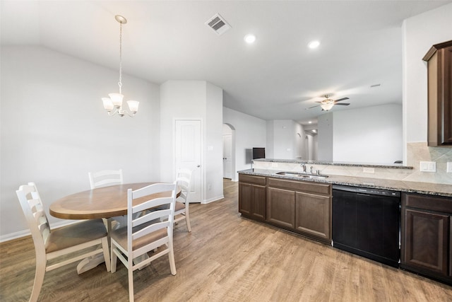 6186 White Oak Leaf Loop, Conroe, TX 77303 - kitchen featuring black dishwasher, a sink, arched walkways, light wood finished floors, and light stone countertops