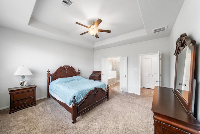 6186 White Oak Leaf Loop, Conroe, TX 77303 - bedroom with a tray ceiling, light colored carpet, baseboards, and ensuite bath