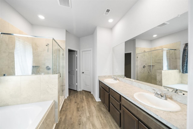 6186 White Oak Leaf Loop, Conroe, TX 77303 - full bathroom with a shower stall, a garden tub, double vanity, wood finished floors, and recessed lighting