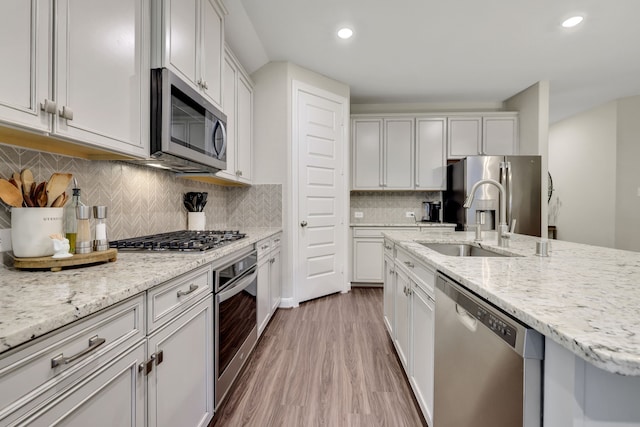 21310 Baldovin Way, Tomball, TX 77375 - kitchen with appliances with stainless steel finishes, wood finished floors, recessed lighting, light stone countertops, and decorative backsplash