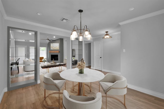 2806 Triway Ln, Houston, TX 77043 - dining area with crown molding, wood finished floors, baseboards, ceiling fan, and a fireplace