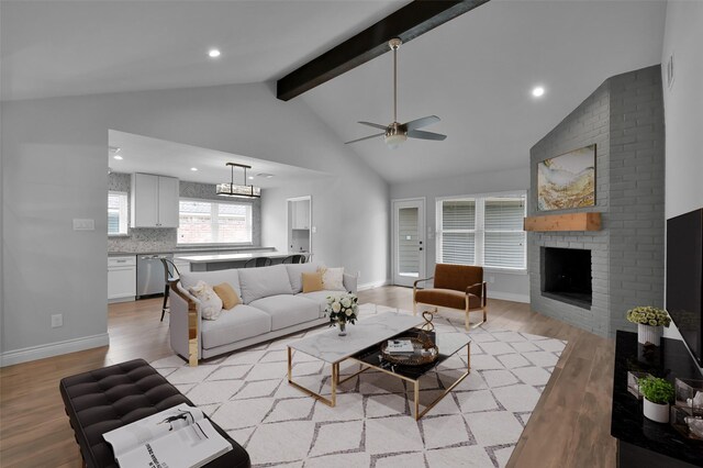 2806 Triway Ln, Houston, TX 77043 - living area with light wood-type flooring, beamed ceiling, ceiling fan, a fireplace, and baseboards