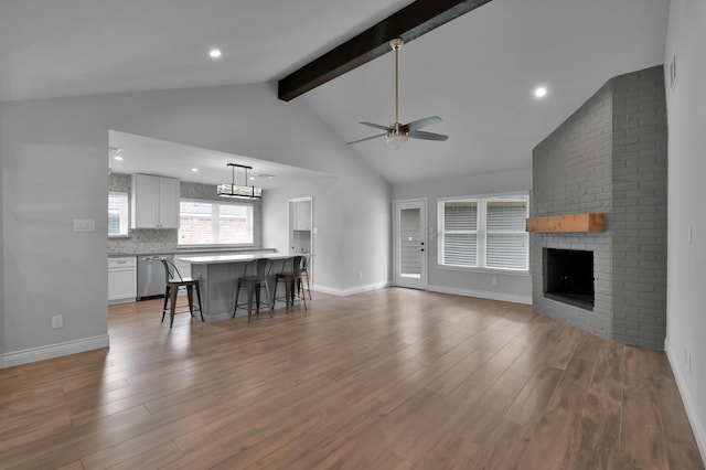 2806 Triway Ln, Houston, TX 77043 - living area with ceiling fan, beamed ceiling, wood finished floors, a brick fireplace, and baseboards
