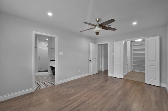 2806 Triway Ln, Houston, TX 77043 - unfurnished bedroom featuring a spacious closet, wood finished floors, recessed lighting, baseboards, and ensuite bathroom