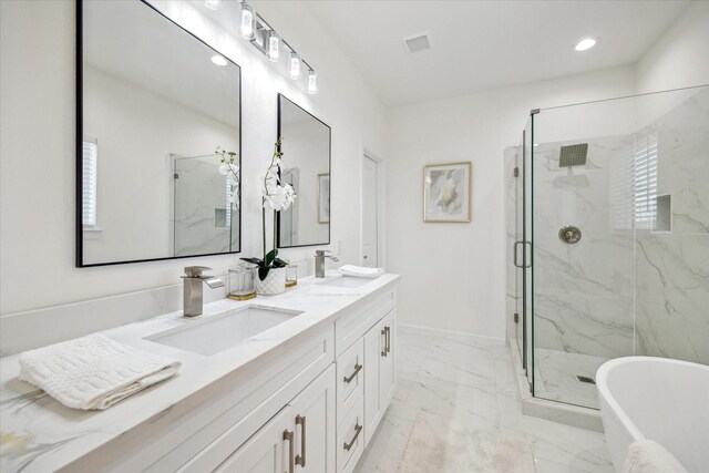 927 Bianco Ln, Houston, TX 77091 - bathroom with marble look tiles, a marble finish shower, a freestanding tub, double vanity, and baseboards