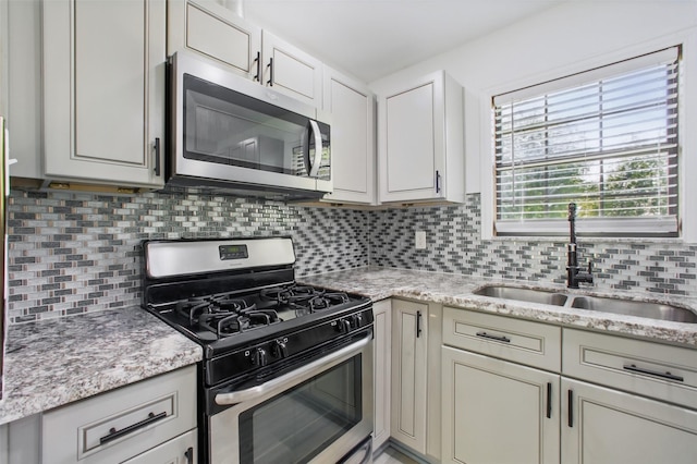 3221 Texas Ave, Texas City, TX 77590 - kitchen with appliances with stainless steel finishes, decorative backsplash, light stone countertops, and white cabinetry