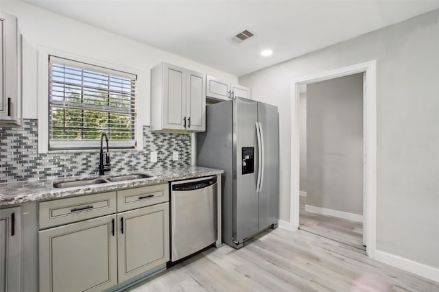 3221 Texas Ave, Texas City, TX 77590 - kitchen featuring stainless steel appliances, tasteful backsplash, light wood-style floors, light stone counters, and recessed lighting