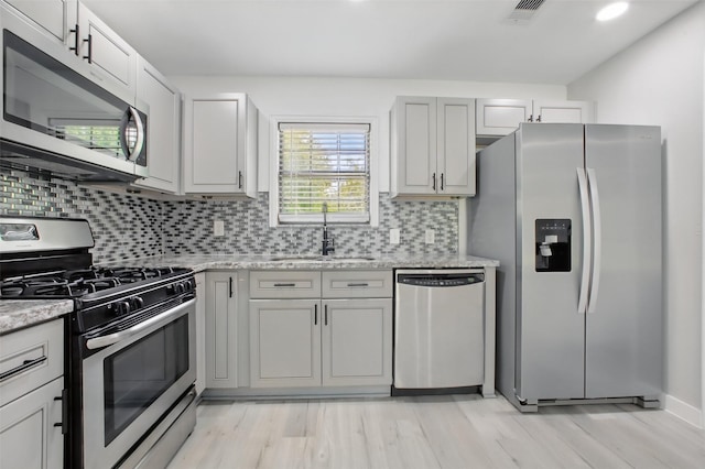 3221 Texas Ave, Texas City, TX 77590 - kitchen with stainless steel appliances, backsplash, light wood finished floors, and light stone counters