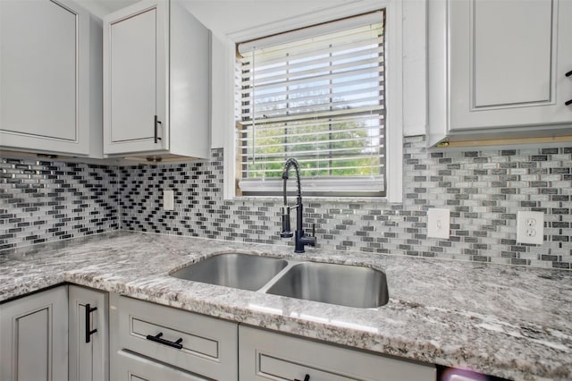 3221 Texas Ave, Texas City, TX 77590 - kitchen featuring decorative backsplash, light stone counters, and white cabinetry