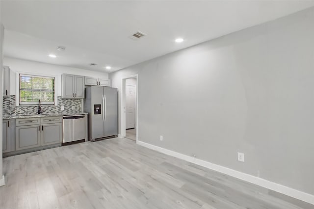 3221 Texas Ave, Texas City, TX 77590 - kitchen with appliances with stainless steel finishes, gray cabinets, light wood finished floors, light countertops, and recessed lighting