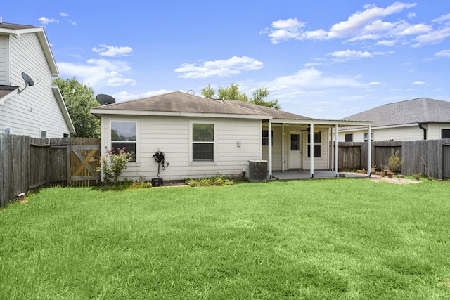 rear view of property featuring a patio area, central AC, and a gate