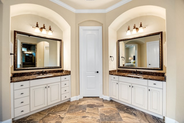 full bathroom featuring connected bathroom, crown molding, baseboards, and two vanities