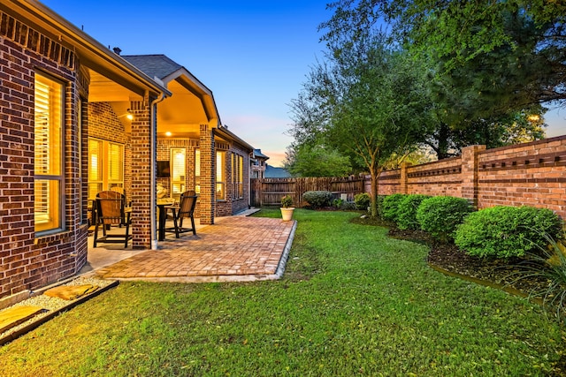 yard at dusk featuring a patio